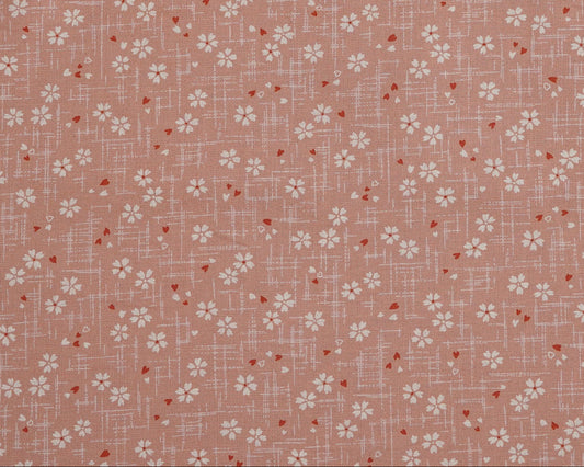 Floral patterned fabric with small white flowers on a pink background