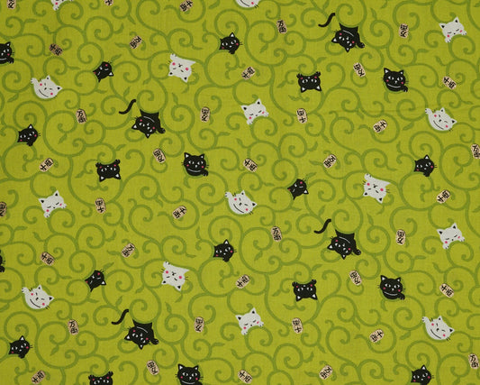 Pattern of black and white cats on a green background
