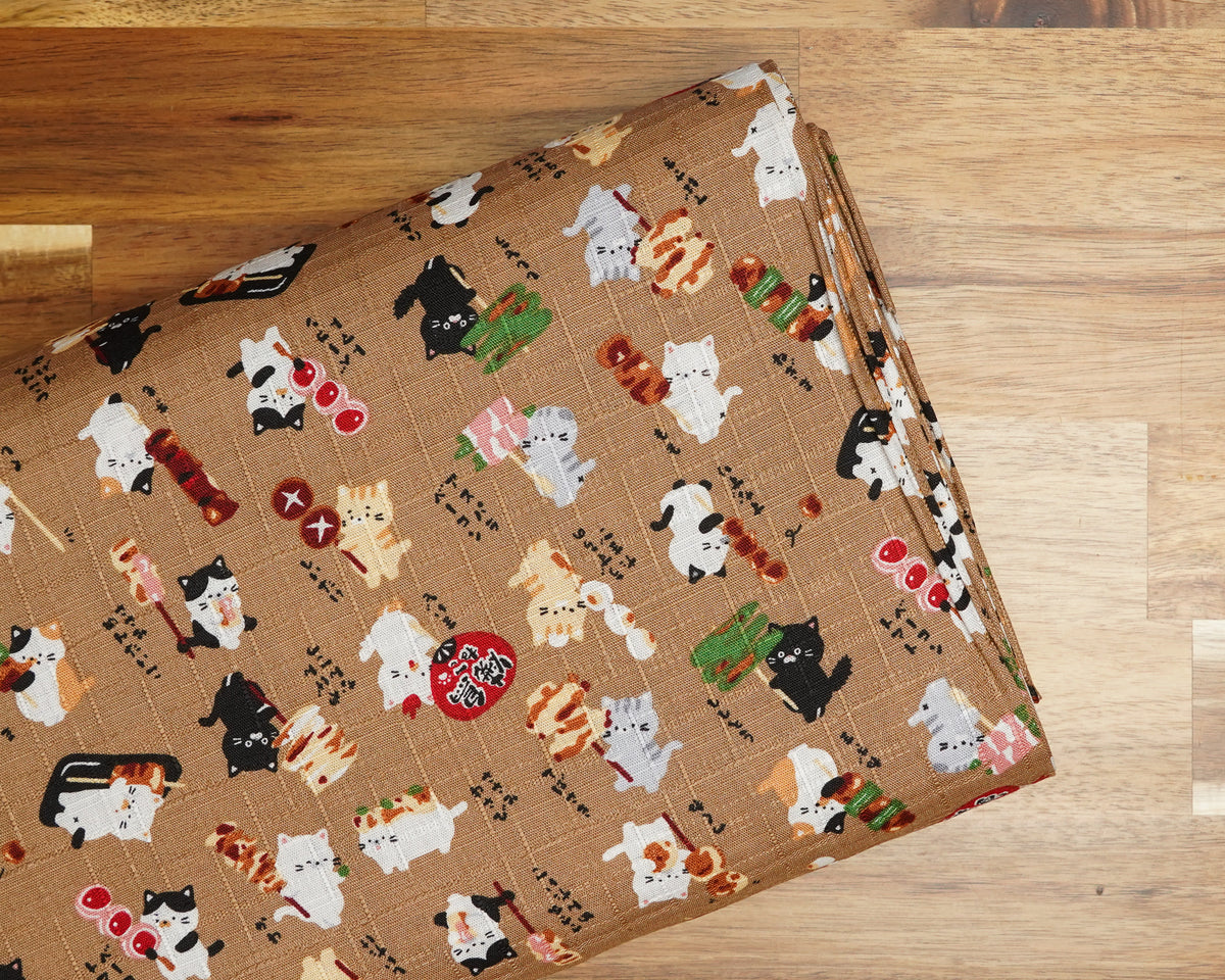 Yakitori Cats on Brown cotton dobby fabric, folded on the bolt