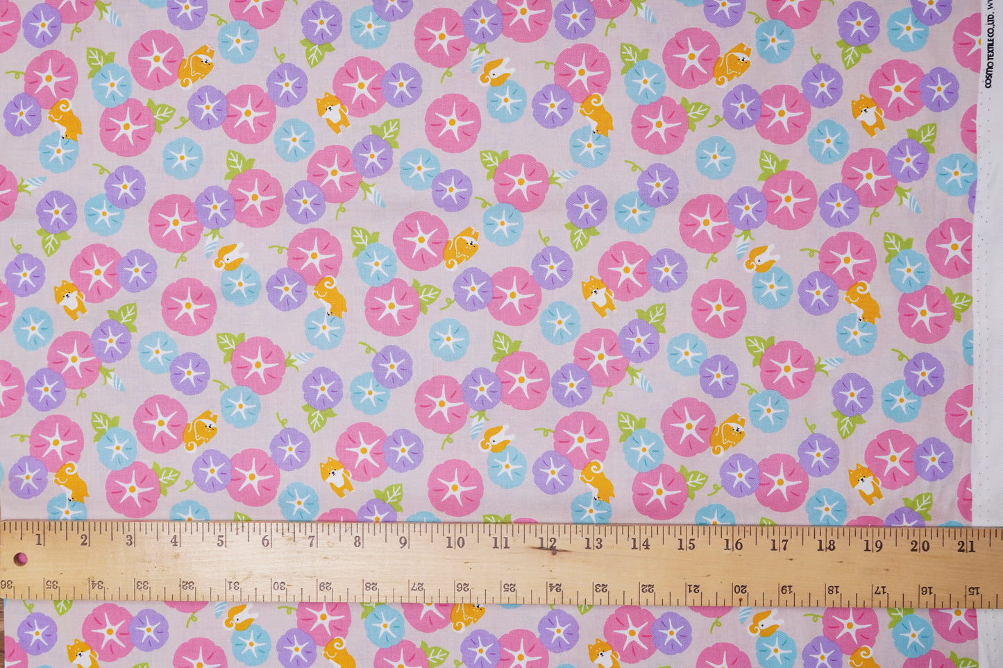 Floral patterned fabric with a ruler at the bottom for scale.