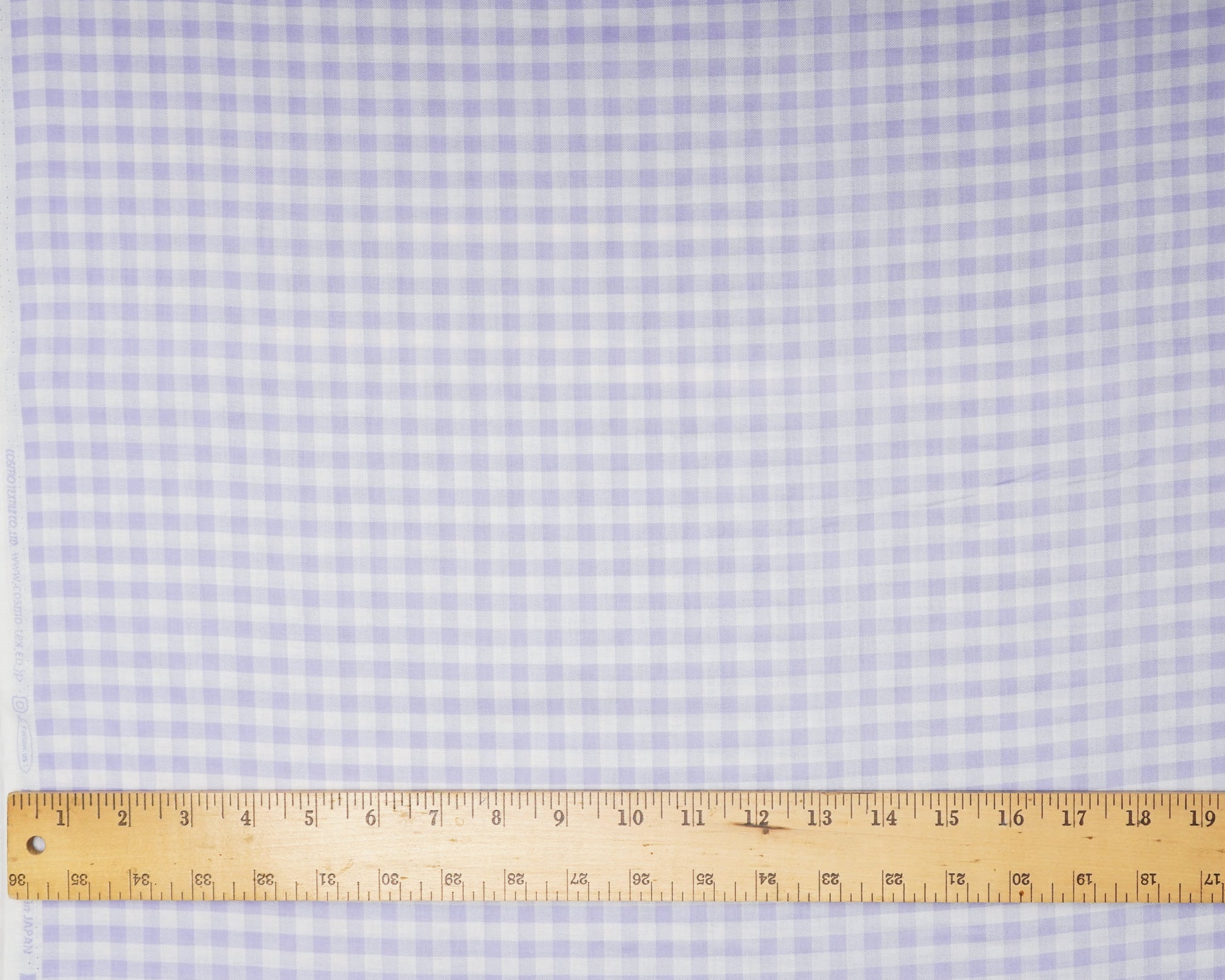 Checkered fabric with a ruler at the bottom for scale
