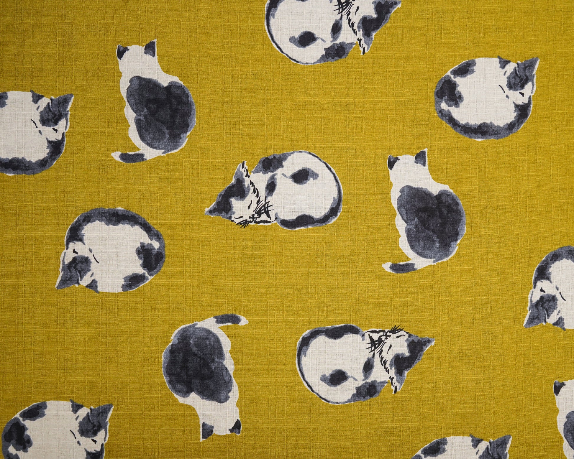 Pattern of black and white cats on a mustard yellow fabric background