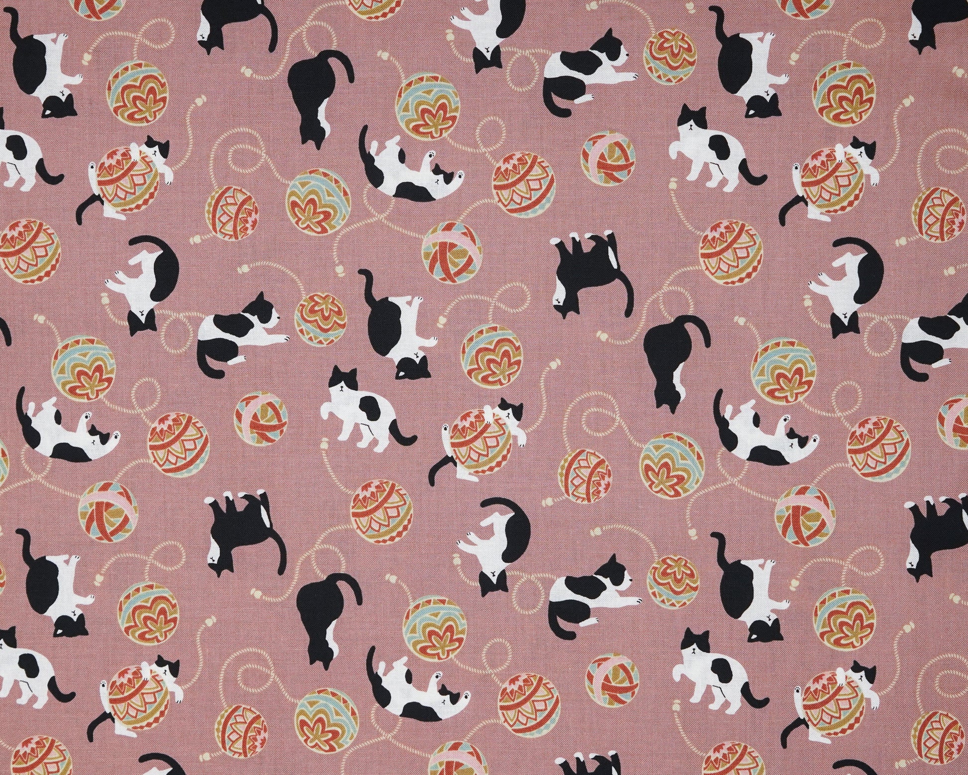 Pattern of black and white cats with temari balls on a pink background