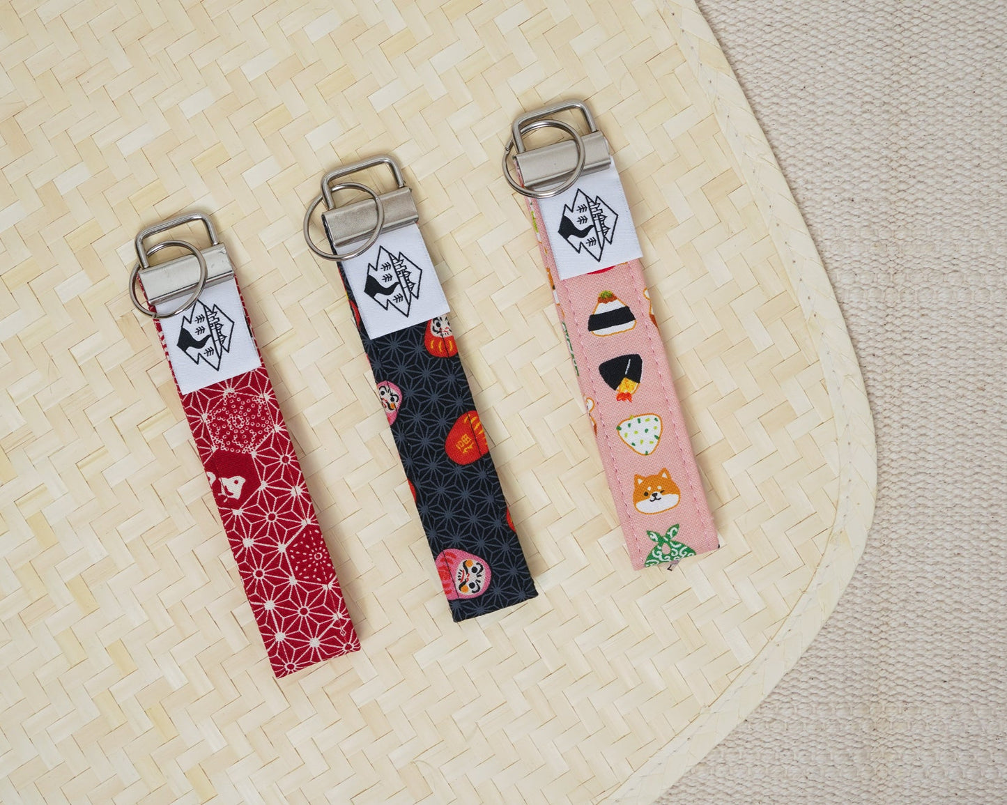 Three keychains with different designs on a textured surface