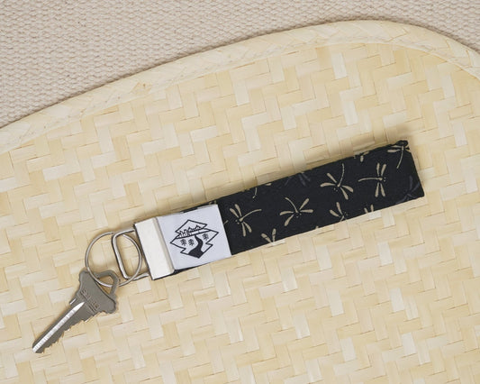 Keychain with a black and white pattern on a beige woven surface